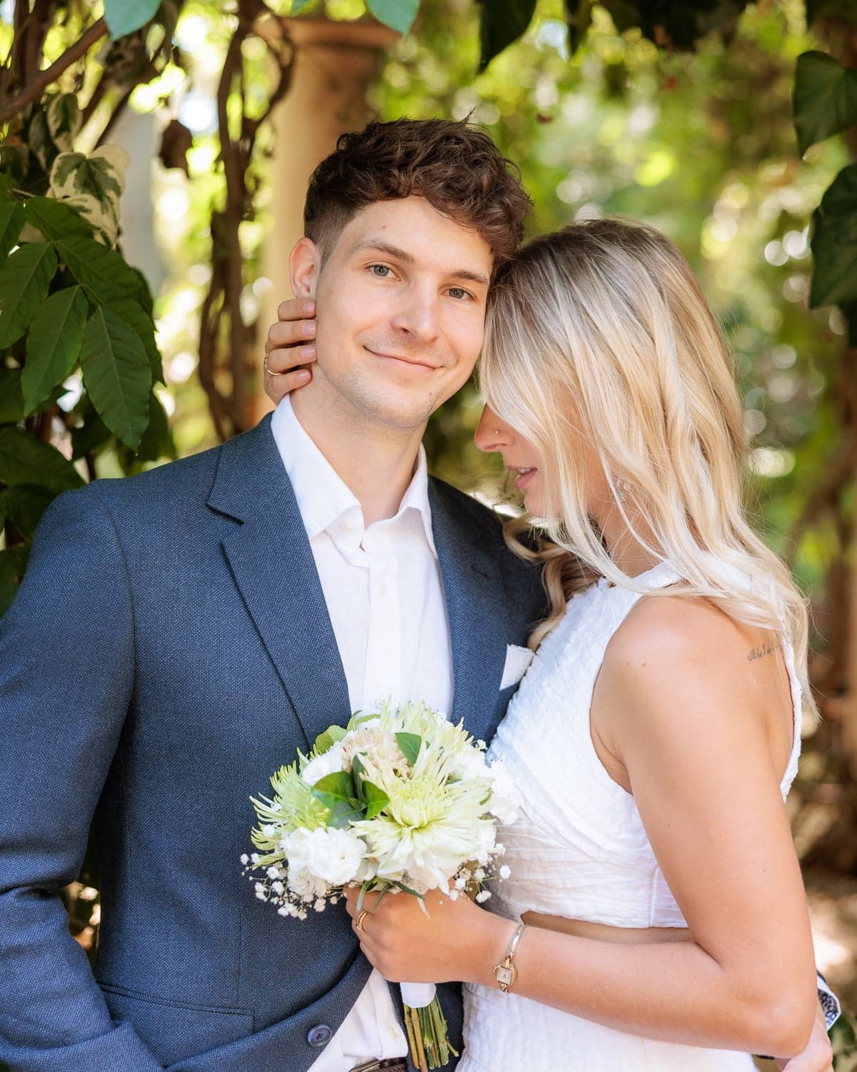 Couple posing together with white bouquet during wedding photography at Nara Peace Gardens, Canberra.